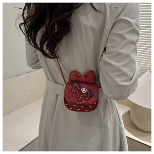 Close-up of girls red mini crossbody bag with a large bow and embroidered horse
