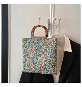 Detail shot of vintage floral jacquard fabric and natural bamboo handles on tote bag