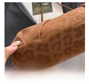 Close-up of leopard pattern embossed suede bag showing professional stitching detail