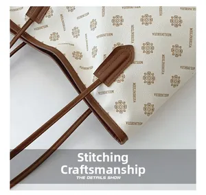 Detail view of the vintage print tote bag showing leather strap stitching and patterns