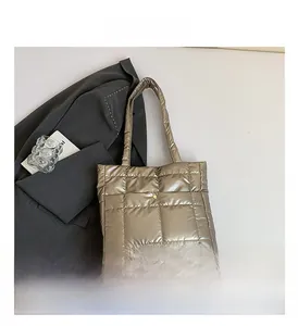 Detail view of champagne quilted tote bag with metallic finish and magnetic snap button