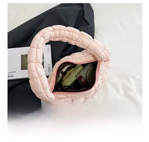 Capacity view of pink quilted puffer shoulder bag showing interior space and daily items