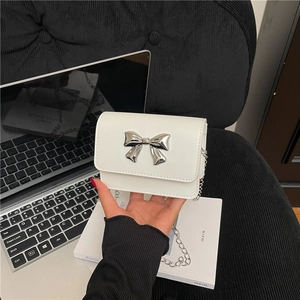 Détail du mini sac en cuir blanc avec nœud métallique argenté et fine bandoulière