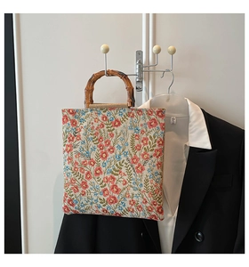 Detail view of square floral tote bag featuring rustic print and carbonized bamboo handles