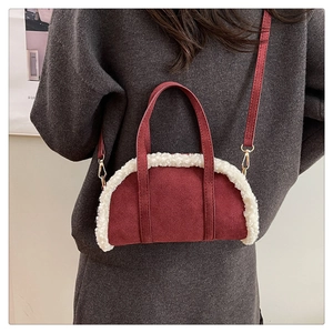 Détail du sac polochon en daim bordeaux avec bordure en peluche blanche et crochets