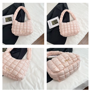 Detail of pink quilted puffer bag with gold hardware and soft padded handle textures