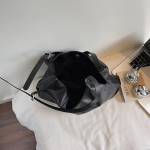 Minimalist large capacity black leather tote bag for women shown with daily essentials