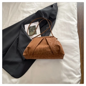 Detail showing leopard print texture and pleated fabric of the stylish shoulder bag