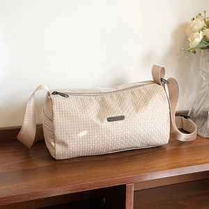 Beige quilted cylinder sports bag with adjustable shoulder strap for yoga and travel