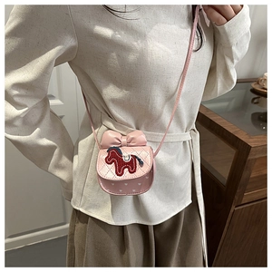 Detail view of quilted pink crossbody bag with red pony embroidery and bow for girls