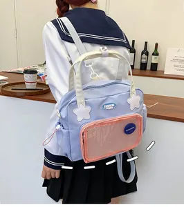 Dettaglio dello zaino giapponese azzurro con tasca a rete rosa e toppe alla moda