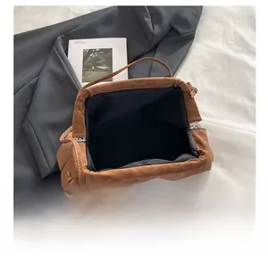 Spacious interior of brown soft leather clasp bag with knotted drawstring detail
