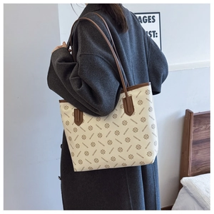 Detail of vintage monogram tote bag featuring large capacity and stylish cream canvas print