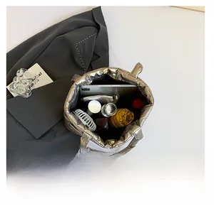 Spacious interior of metallic quilted tote bag holding a tablet and accessories