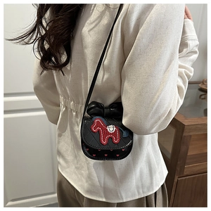 Detail of black quilted mini crossbody bag featuring red horse embroidery and bow decoration