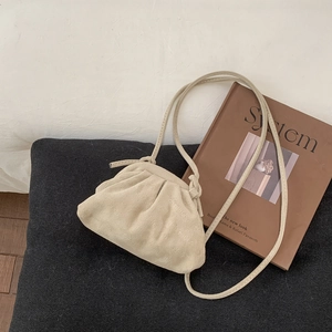 Minimalistische beige geplooide wolkentas met suède textuur en slanke schouderband