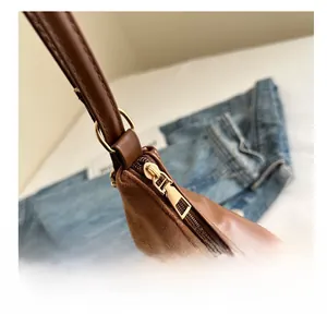 Detail of smooth gold zipper and premium brown leather texture on a tote bag