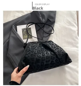 Detail of leopard print pleated bag texture with black shoulder strap and magazine
