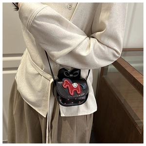 Detail showing the red pony embroidery and black bow on this mini crossbody bag