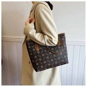 Detail view of large retro tote bag with brown printed pattern and shoulder strap