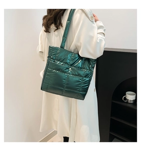 Detail of dark green quilted tote bag with metallic finish and magnetic snap button