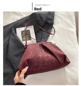 Detail of burgundy pleated underarm bag featuring leopard print and slim shoulder strap