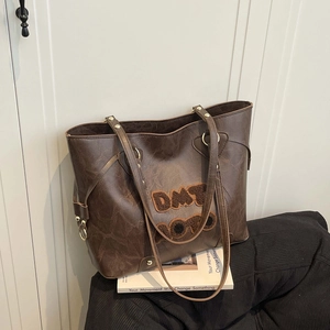 Deep brown leather tote bag with plush DMT letters for women's stylish commuting use