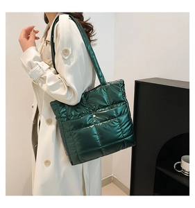 Close-up of green quilted down tote bag with metallic finish and silver buckle