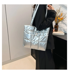 Detail of silver puffer tote bag with quilted diamond pattern and metallic glossy finish