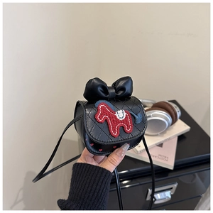 Close-up of a black quilted mini crossbody bag with a red embroidered horse and bow