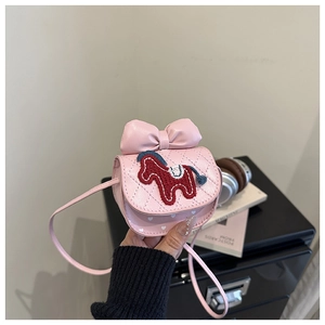Detail of pink quilted cross-body bag featuring a leather bow and horse embroidery