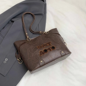 Minimalist dark brown tote bag with vintage cracked leather texture and orange letter patches