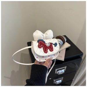 Detail of white mini crossbody bag featuring a large bow and embroidered horse pattern