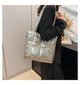 Close-up of a silver quilted down tote bag with a high-gloss metallic finish and soft texture