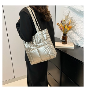 Close-up of metallic silver quilted tote bag showing high-capacity design and sleek straps