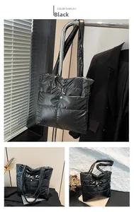 Detail of black quilted tote bag with glossy finish and small golden buckle pocket
