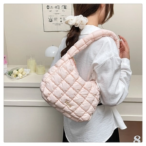 Close-up of pink quilted cloud bag with puffer bubble texture and metal logo detail