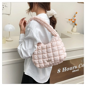 Detailed view of pink quilted cloud bag featuring soft padded texture and gold logo plate
