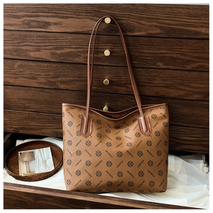 Detailed close-up of brown faux leather tote bag with elegant geometric monogram print