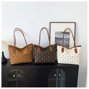 Detailed display of three patterned tote bags in brown, coffee, and beige on a stylish cabinet