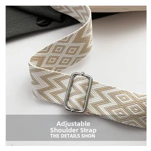 Detail of adjustable wide shoulder strap with beige geometric weave and silver metal buckle