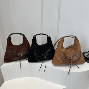 Three large suede bucket bags in coffee, black, and camel with butterfly knot detail