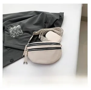 Detail view of cream leather crossbody bag with wide strap and matching coin purse pouch