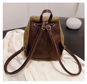 Detail of adjustable thin straps and faux fur trim on a brown leather backpack back