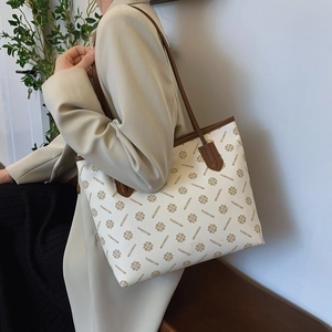 Large vintage print tote bag with brown leather trim and retro monogram pattern