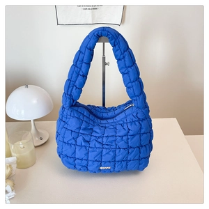 Detail view of quilted puffer bag in royal blue glossy fabric with cloud texture finish