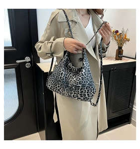 Gros plan sur un sac hobo à motif léopard avec bandoulière sur un trench-coat