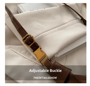 Detail of adjustable gold buckle and premium brown leather strap on shoulder bag