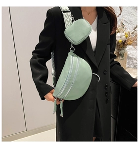 Close-up of mint green crescent bag with textured faux leather and woven shoulder strap