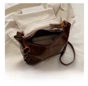 Detail of dark brown tote bag showing spacious interior and soft leather texture
